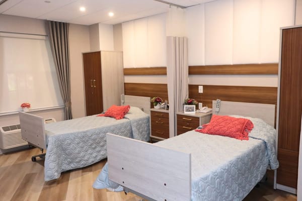 Two twin beds in a well-lit shared room