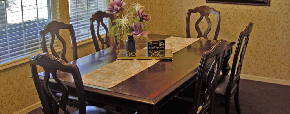 A dining room table set with flowers.