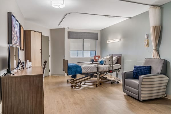 Bright interior of a resident room with hospital bed