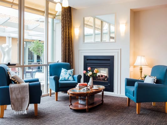 Cozy common area with blue chairs and a fireplace