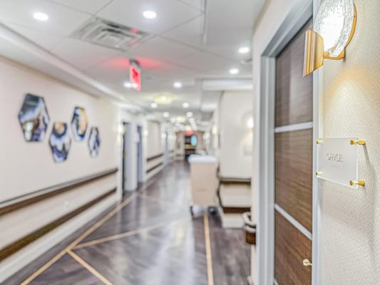 Hallway with office signage and decorative wall art