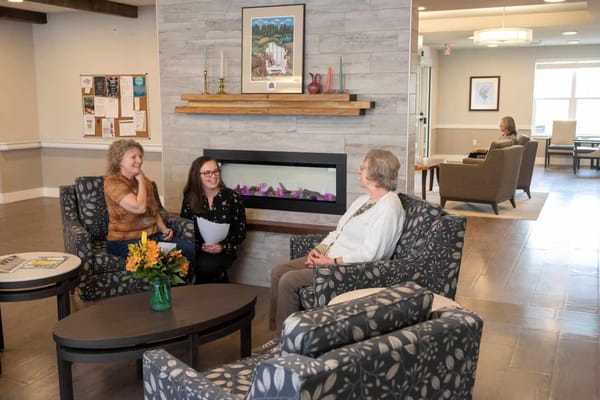 Residents and staff chatting in a cozy lounge area