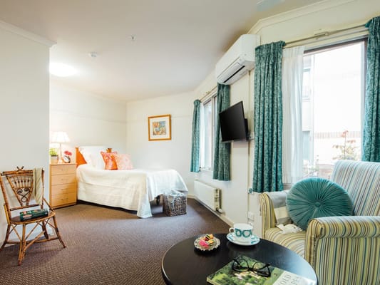 Cozy resident room with a bed and seating area