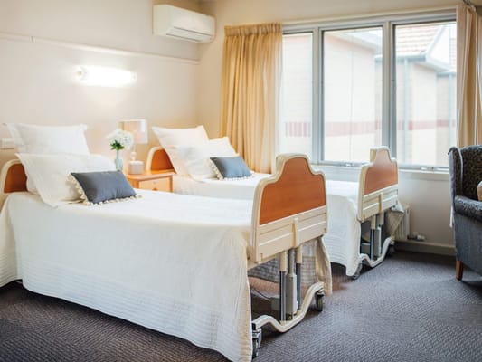 A cozy shared room with two beds and natural light