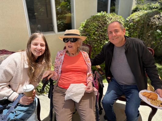 A resident with two visitors enjoying the outdoors