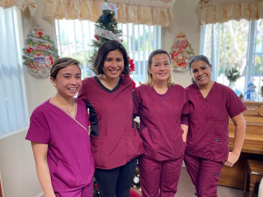 Four staff members smiling in a festive indoor setting