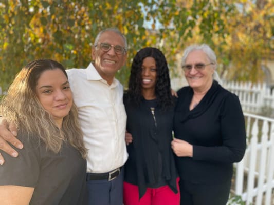Staff and residents smiling together outdoors