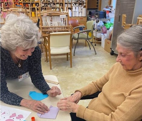 Staff member engaging with a resident in an activity room