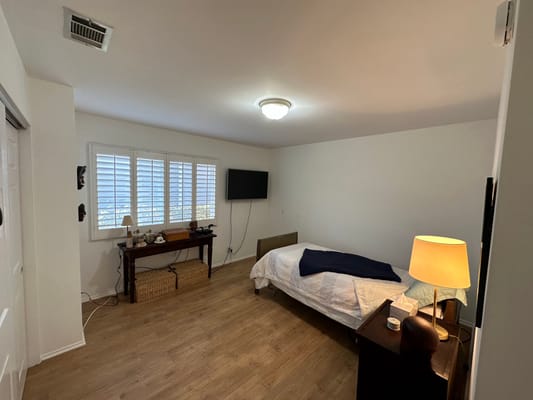 Clean private resident room with a bed and lamp