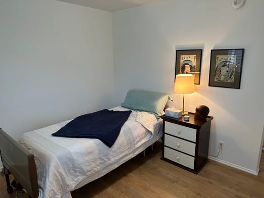 Cozy private resident room with a bed and lamp