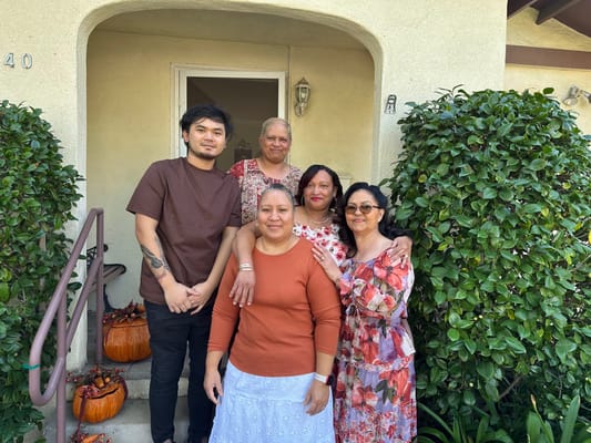 Residents and staff posing outside the facility entrance