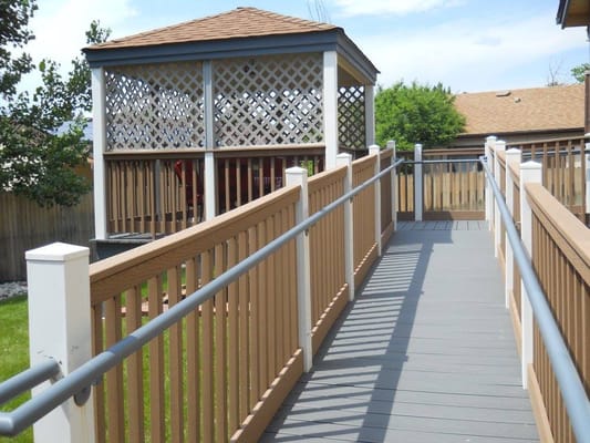 Wooden ramp leading to a gazebo in a garden