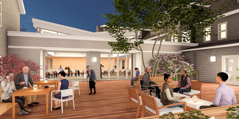 Residents enjoying a patio space with tables and flowers