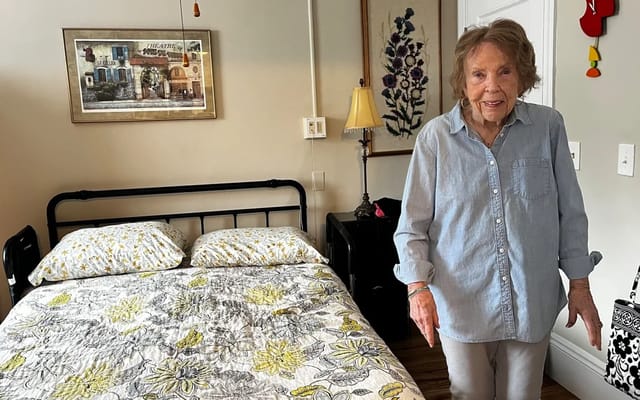 Resident standing in her furnished room.