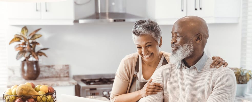Two smiling residents in a kitchen setting