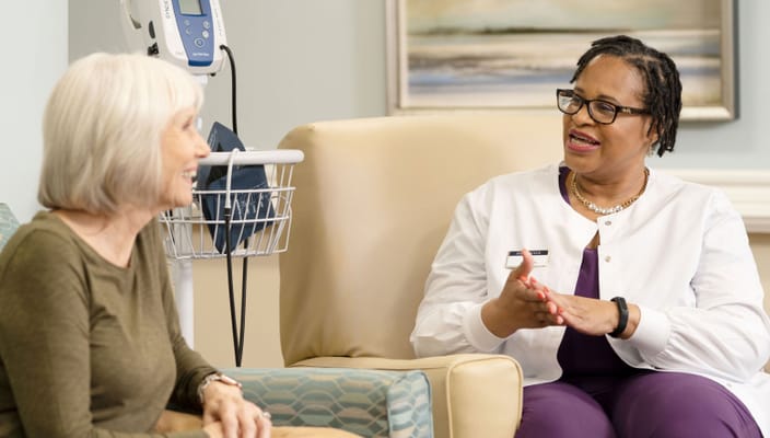 Staff member talking with a resident in a cozy chair