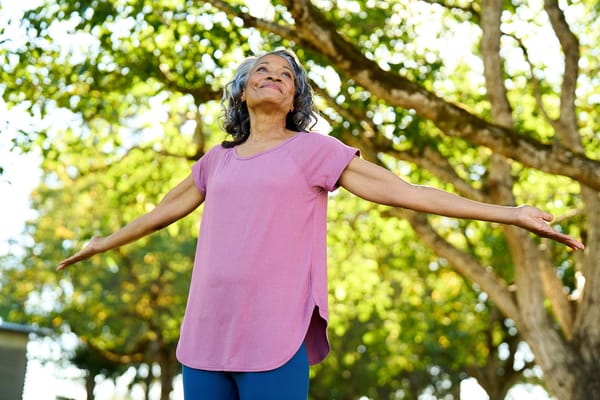 A woman enjoying the outdoors with open arms