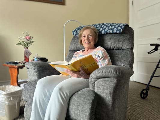 Resident enjoying a book in a cozy chair