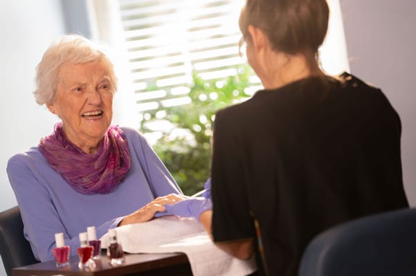 Resident enjoying a manicure session with staff member