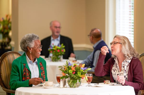 Two residents enjoying dessert in a dining area