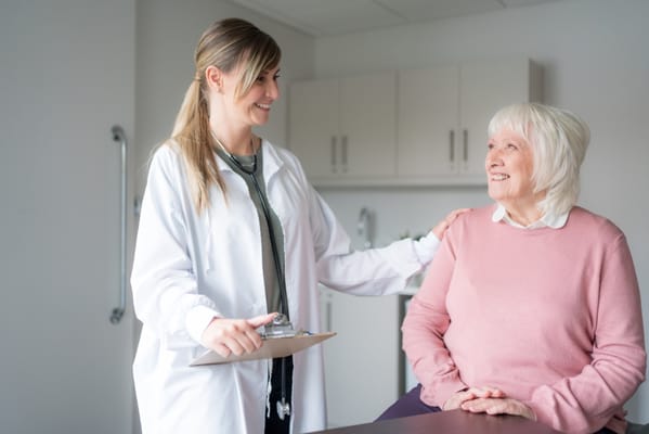 Healthcare professional smiling with a senior resident