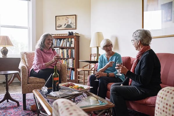 Three residents enjoying drinks and snacks in a common area