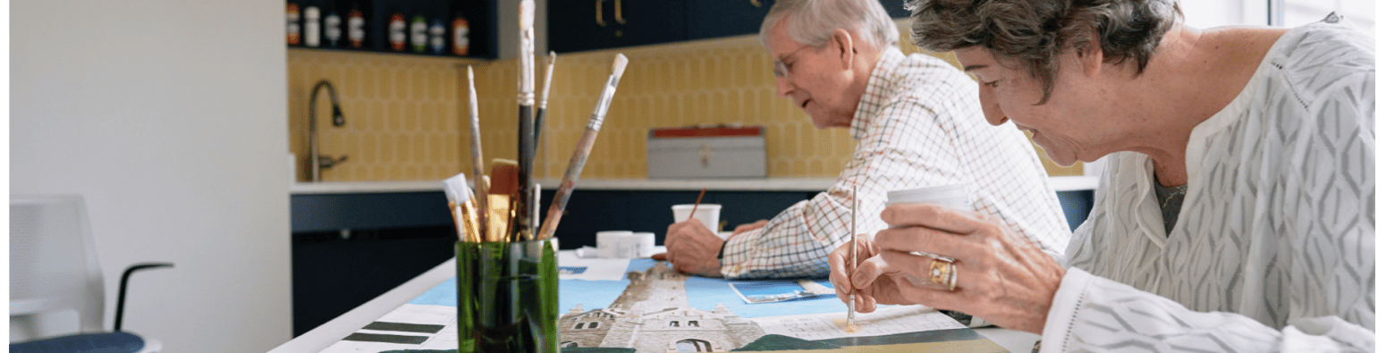 Residents engaged in an art activity at a communal table