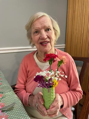 Resident holding a bouquet of flowers indoors
