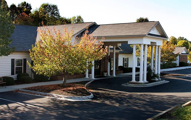 Exterior view of the assisted living facility with trees and entrance