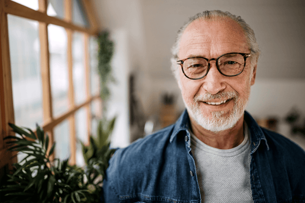 Close-up of a smiling senior man in a bright interior