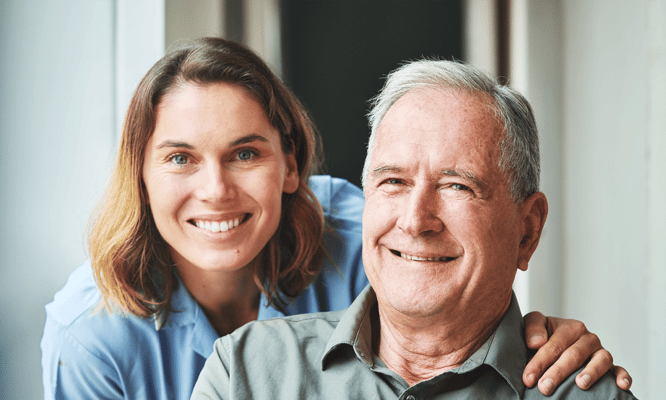 Staff member with resident smiling in a brightly lit room