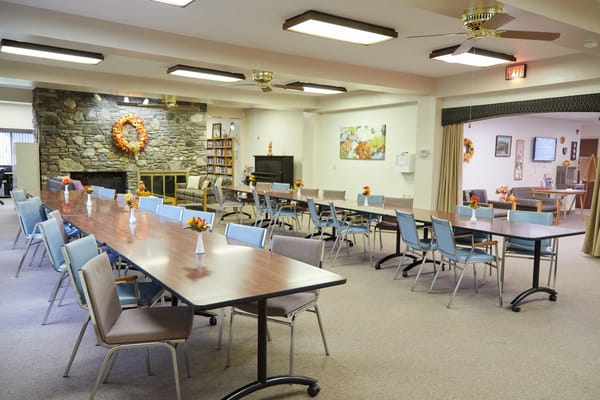 Interior view of a community dining area with tables and decorations