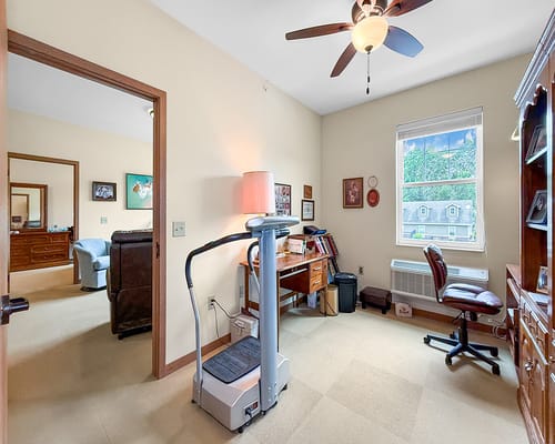 Comfortable resident room with a desk and exercise equipment
