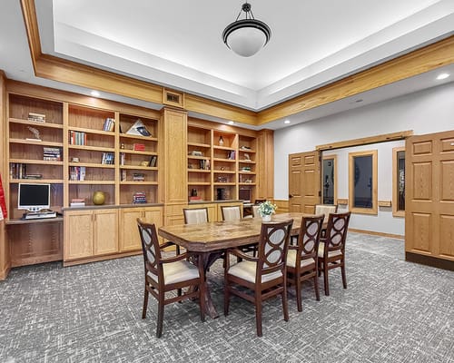 Bright common area with a large table and bookshelves
