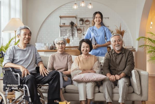 Residents and staff smiling together in a common area