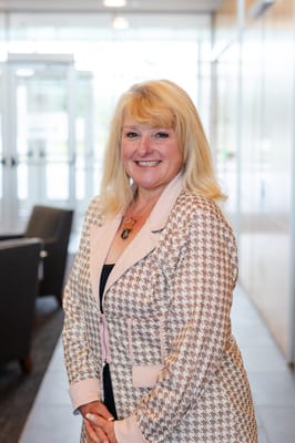 Staff member smiling in a well-lit lobby area