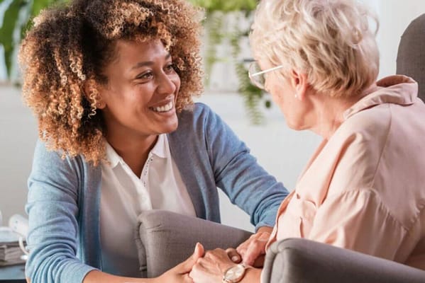 A caregiver and senior woman sharing a warm conversation