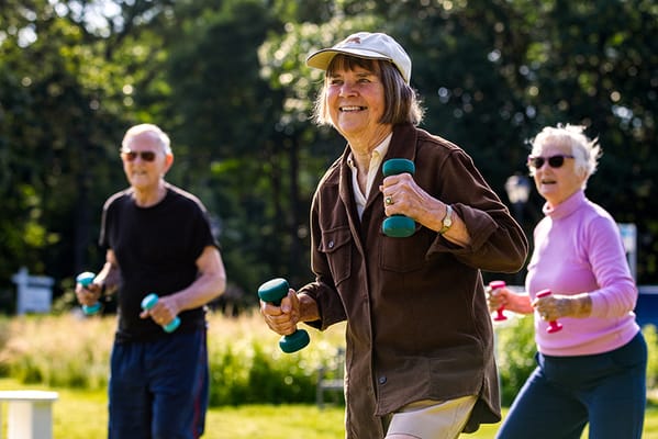 Seniors exercising outdoors with dumbbells