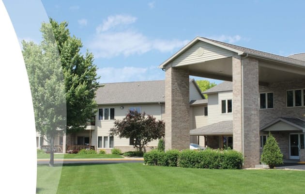 Exterior view of a senior living facility with grass