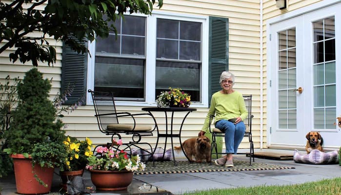 A resident enjoying the outdoor garden with two dogs
