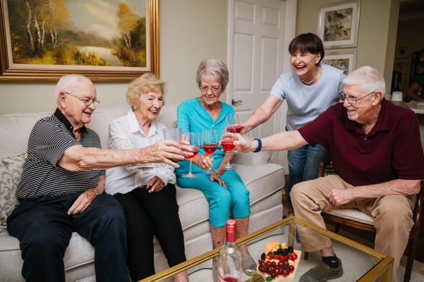 Residents toasting with drinks in a cozy common area