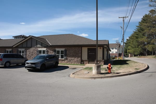 Exterior of a senior living facility with parked cars