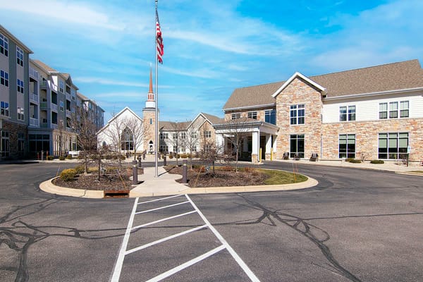 Exterior view of All Saints Neighborhood facility with flagpole