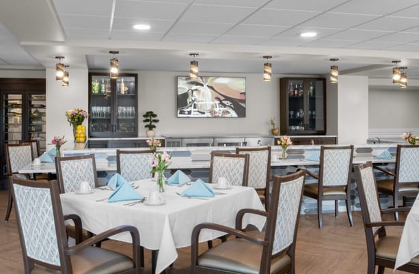 Dining room with neatly set tables and a TV