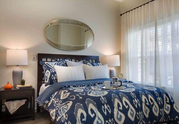 Cozy resident bedroom with decorative bedding and lamps