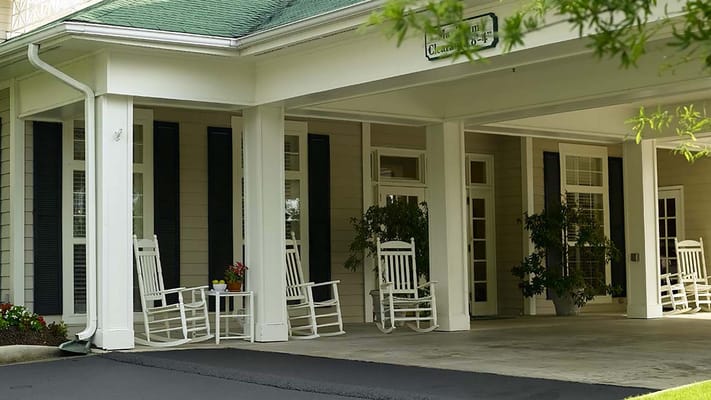 Front entrance of Atria Forest Lake with rocking chairs