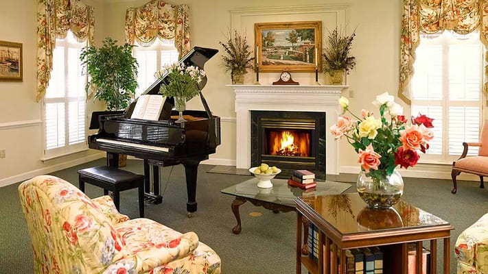 Bright and cozy common area with piano and fireplace