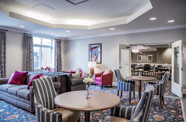 Comfortable lounge with sofas and chairs in a senior living facility.