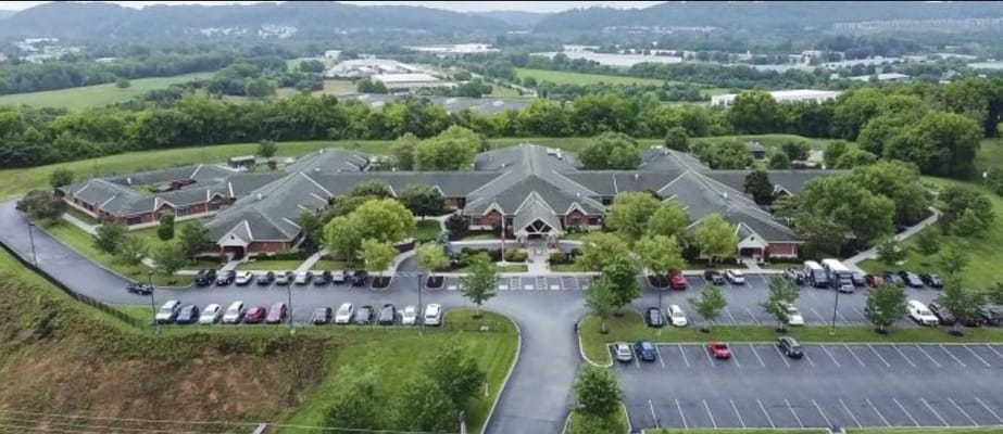 Aerial view of a senior living facility with surrounding greenery