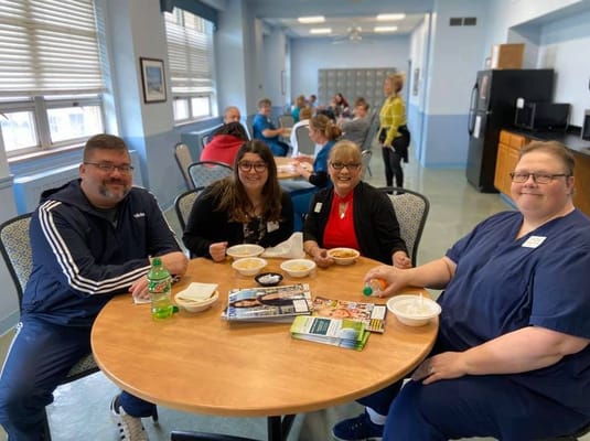 Residents and staff enjoying a meal together in the dining area
